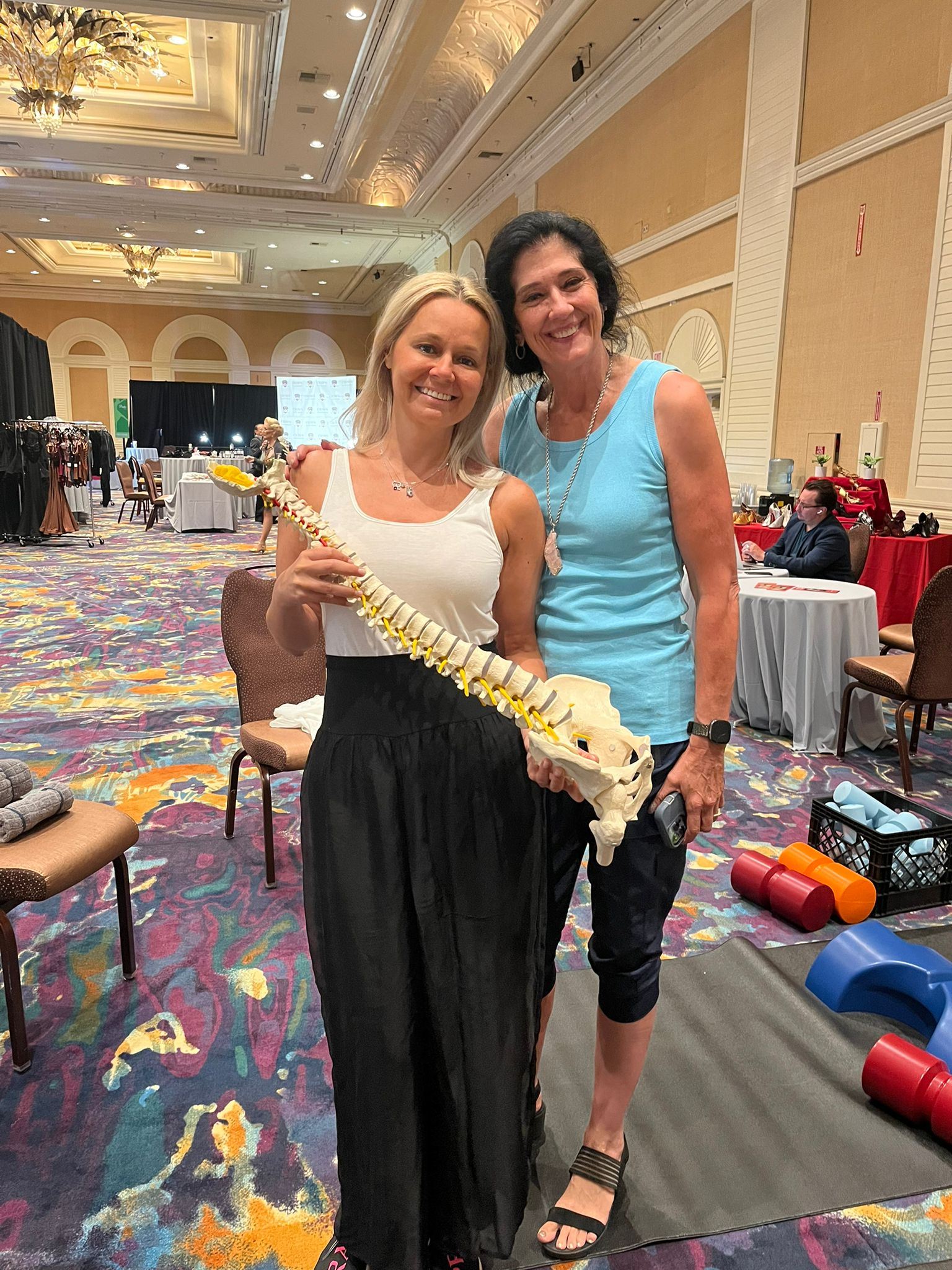 Eileen Durfee holding a spine model while teaching at a wellness event