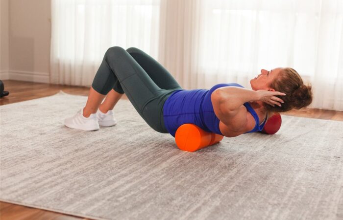 Firm foam roll positioned under the mid-back for spinal extension