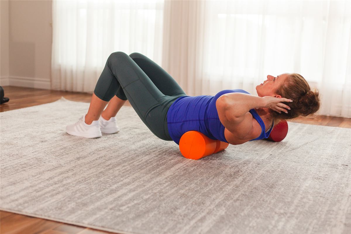 Firm foam roll positioned under the mid-back for spinal extension