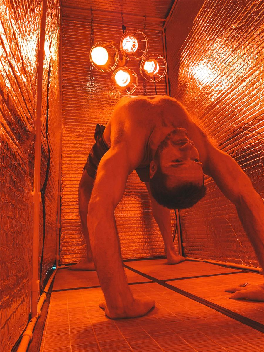 Hot yoga wheel pose inside a Sauna Fix near infrared sauna tent