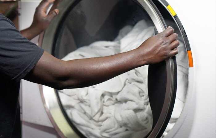 Loading white linens into a front-load washing machine for a fragrance-free wash