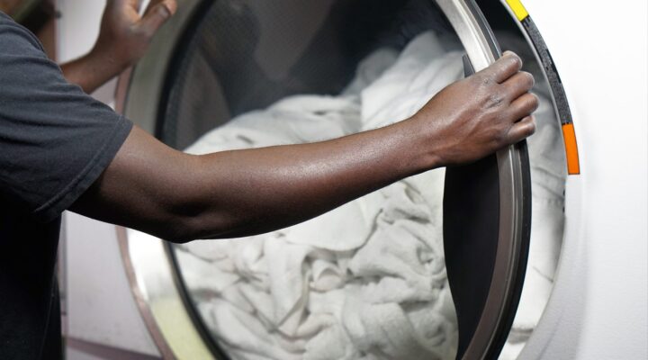 Loading white linens into a front-load washing machine for a fragrance-free wash