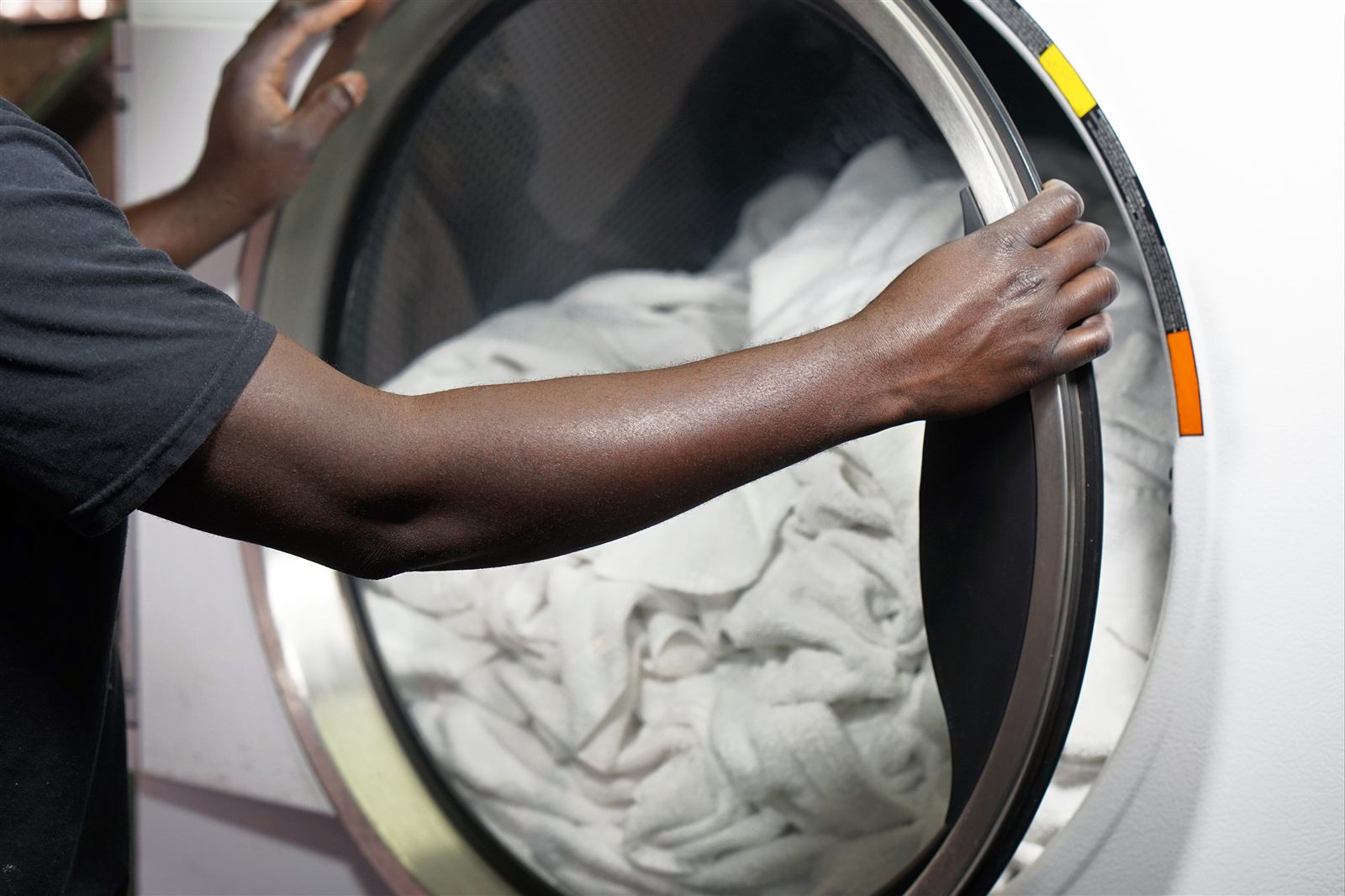 Loading white linens into a front-load washing machine for a fragrance-free wash