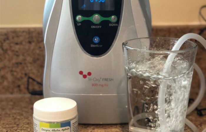 Tri-Oxy FRESH with a glass of water and Healthy Salt minerals on the counter