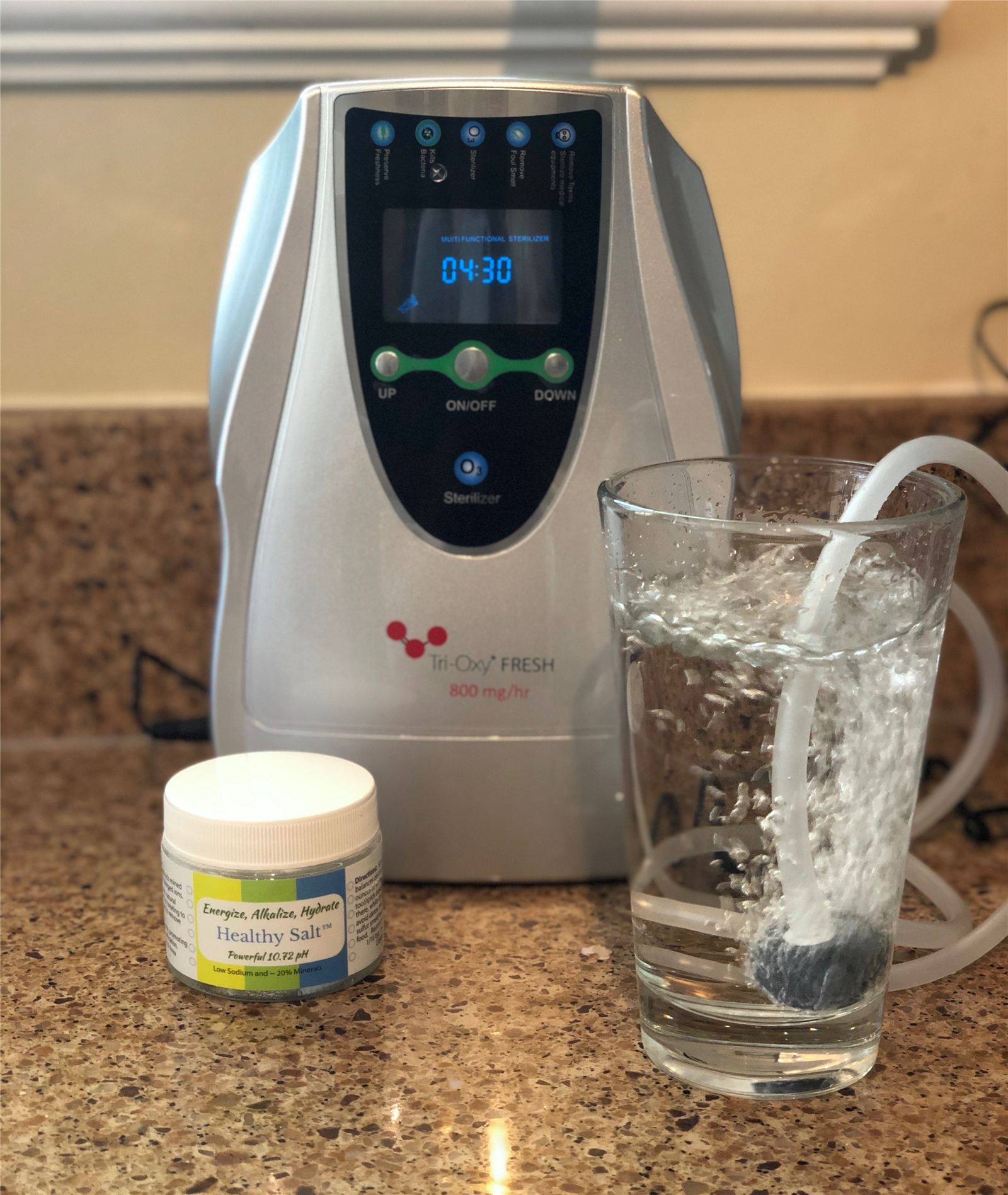 Tri-Oxy FRESH with a glass of water and Healthy Salt minerals on the counter